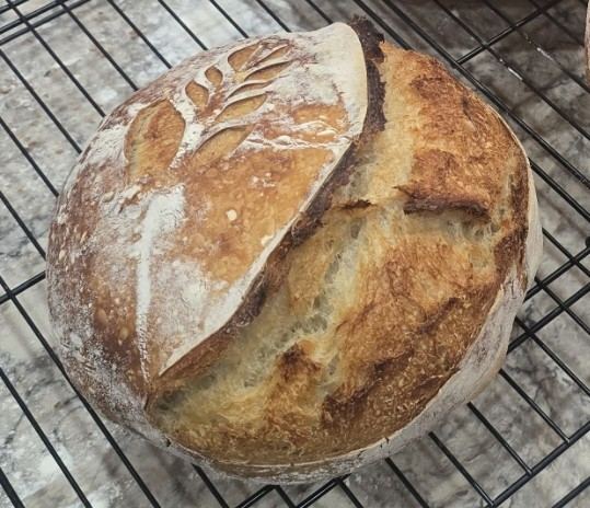 Scored sourdough loaf cooling on a wire rack